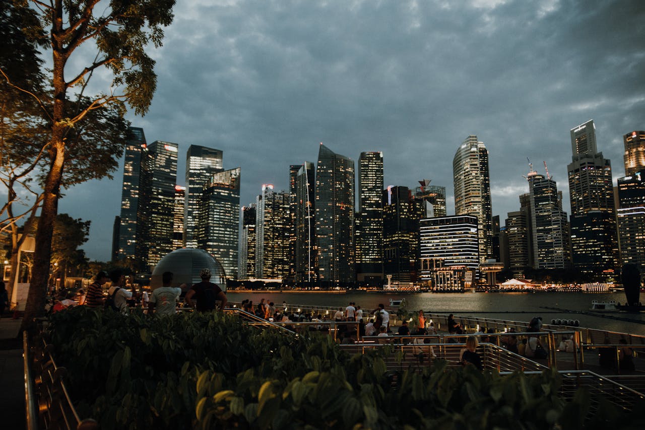 about-01 Captivating view of the Singapore skyline at twilight with city lights reflecting on the water.